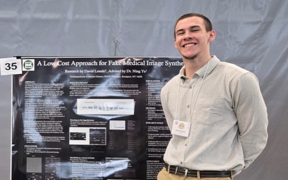 David Lonski standing next to his research poster
